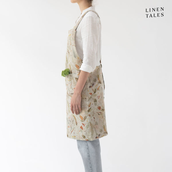 Linen apron, combining the durability quality of Lithuanian linen with stonewashed softness and appealing print and colour. A cross back pinafore design to slip on and off, with no ties. Shown in Leaves print on Natural.