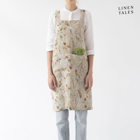 Linen apron, combining the durability quality of Lithuanian linen with stonewashed softness and appealing print and colour. A cross back pinafore design to slip on and off, with no ties. Shown in Leaves print on Natural.