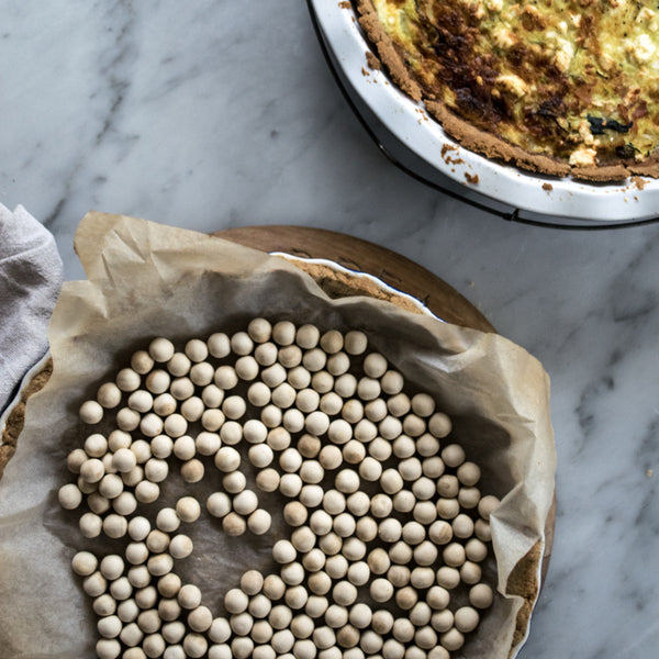 Use ceramic pie weights when blind baking to prevent your pastry from shrinking, bubbling or rising before spreading filling across a golden pie base.