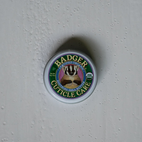 Badger Balm Cuticle Care treats nails and cuticles kindly. Contains shea butter, extra virgin olive oil, beeswax, castor oil, geranium, mandarin, lemongrass, cardamon, rosemary verbenone, litsea, seabuckthorn, and ginger.