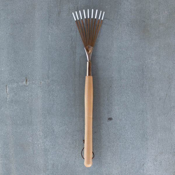 An essential Border Hand Shrub Rake, polished stainless steel and certified FSC ash handle.