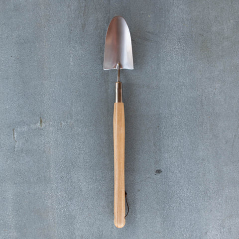 An essential Border Hand Trowel, polished stainless steel and certified FSC ash handle.