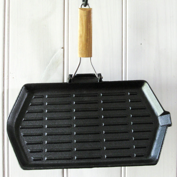Sear meat in the kitchen or over the campfire with a pre-seasoned cast iron skillet, square 24cm x 24cm, square large 28cm x 28cm, or oblong 21cm x 35cm, with folding timber handle. 