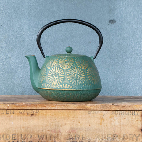 Cast iron teapot, green with gold daisy print and enamelled interior with removable mesh infuser.