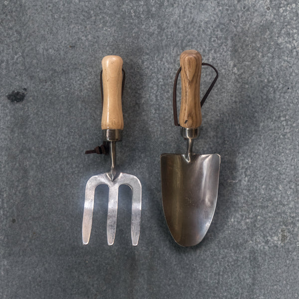 Children's trowel and fork set, made from stainless steel and ash timber with leather hanging straps. Built to last gardening tools with strong handles and made from quality metal, they will take sturdy digging in the garden alongside mum and dad or grandparents.