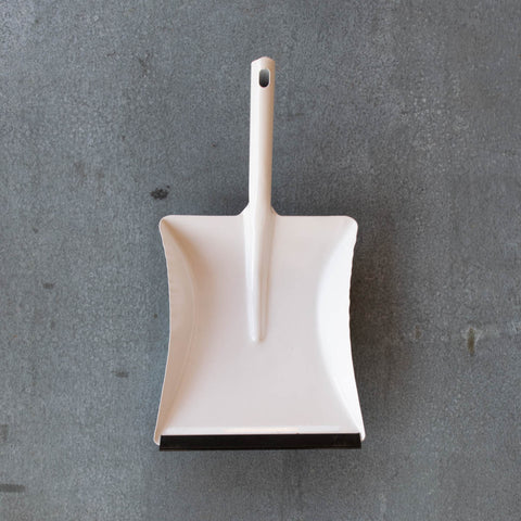 A simple dust pan made of one piece of moulded metal in white, with a removable rubber lip.