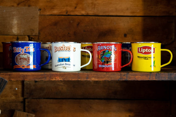 Enjoy the nostalgia and iconic vintage advertising brands of our enamel mugs, featuring the Bushell's logo, against a cream background.