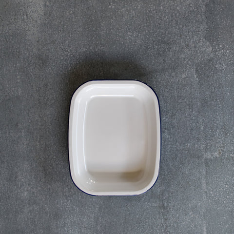 Falcon enamel roasting pan in white with a blue rim. Dimensions, 26cm x 21cm x 3.5cm. Falcon enamelware is renowned for it good and even browning. 