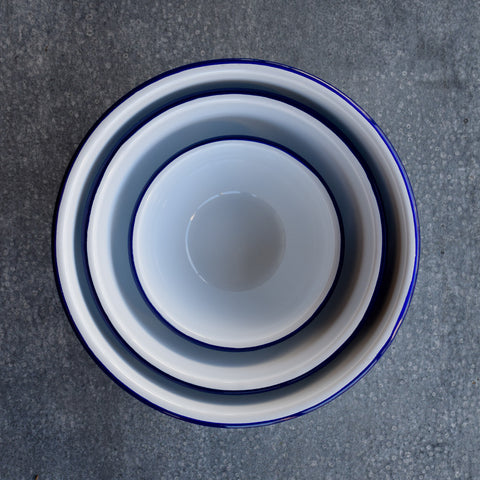 Falcon Enamelware Mixing Bowls, set of three, in white with a blue rim. Think beyond mixing, to storing and serving. Ideal for a shared salad, serving a bowl of olives or whisking an egg. 