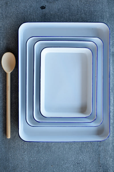 The Falcon enamelware baking tray in white with a blue rim is the perfect slice tray, but also great for cooking biscuits, or using as a butchers' meat tray at the barbecue.