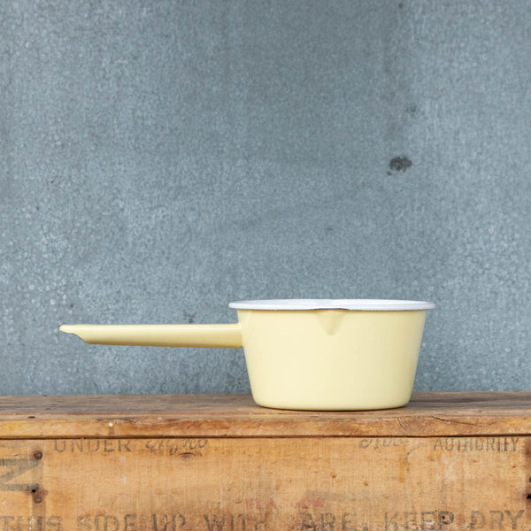 Use our Falcon enamel saucepan in two-tone yellow exterior and white interior to brew chai, warm milk, or heat a sauce on the stove. The saucepan has two lips for easy pouring, is 850ml, 8cm deep and 14cm diameter. 