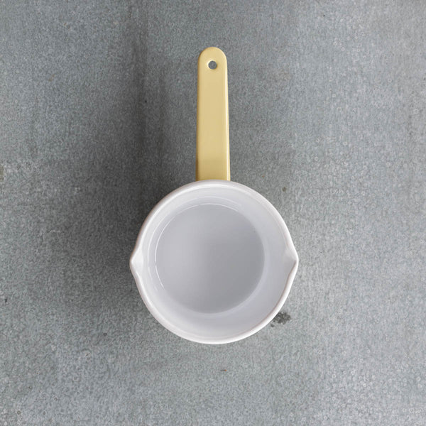 Use our Falcon enamel saucepan in two-tone yellow exterior and white interior to brew chai, warm milk, or heat a sauce on the stove. The saucepan has two lips for easy pouring, is 850ml, 8cm deep and 14cm diameter. 