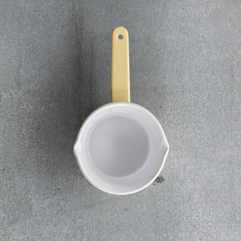 Use our Falcon enamel saucepan in two-tone yellow exterior and white interior to brew chai, warm milk, or heat a sauce on the stove. The saucepan has two lips for easy pouring, is 850ml, 8cm deep and 14cm diameter. 