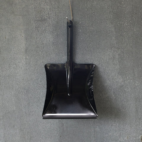 A simple dust pan made of one piece of moulded metal in black, with a removable rubber lip.