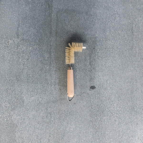 A sink drain cleaning brush with a 90 degree bend for reaching awkward to access places. 