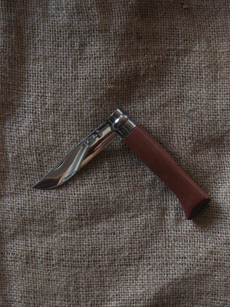 An Opinel No. 8 pocket knife with a stainless steel blade and specialty timber handle, in oak, olive, bubinga or walnut. Current stock may not be stamped 'Opinel'.Made in France since 1890, Opinel knives are reliable, robust and easy to use. They have a trademark safety ring, which locks the blade in the open or closed position.