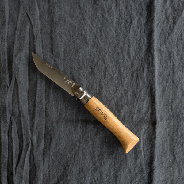 An Opinel No. 8 pocket knife with a stainless steel blade and specialty timber handle, in oak, olive, bubinga or walnut. Current stock may not be stamped 'Opinel'.Made in France since 1890, Opinel knives are reliable, robust and easy to use. They have a trademark safety ring, which locks the blade in the open or closed position.