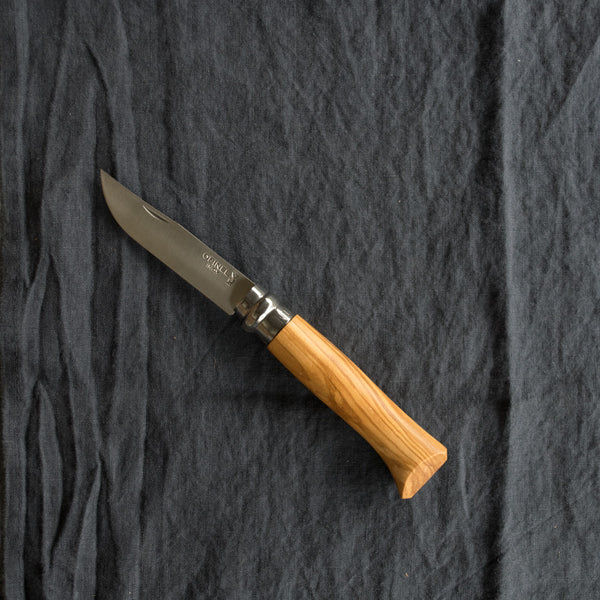 An Opinel No. 8 pocket knife with a stainless steel blade and specialty timber handle, in oak, olive, bubinga or walnut. Current stock may not be stamped 'Opinel'.Made in France since 1890, Opinel knives are reliable, robust and easy to use. They have a trademark safety ring, which locks the blade in the open or closed position.